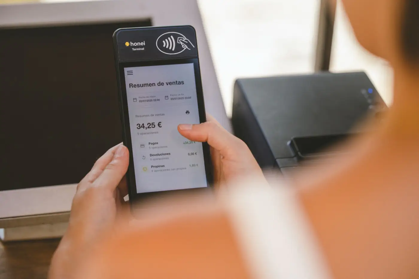 Una camarera revisa el resumen de ventas en el honei Terminal